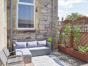 patio z 2 krzesłami i kanapą na balkonie w obiekcie Sorbie Villa w mieście Stevenston