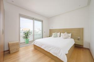 una camera da letto bianca con un letto grande e una finestra di anfa Louise a Casablanca