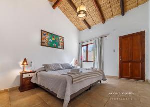 1 dormitorio con 1 cama y puerta de madera en Nido de cóndores en Purmamarca