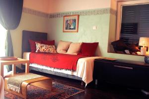 a bedroom with a red bed and a window at Beautiful Vintage House in Vis