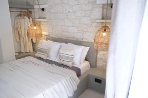 1 dormitorio con 1 cama con sábanas y almohadas blancas en Derin Alacati, en Alacati