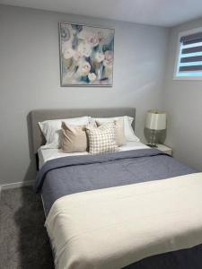 una camera da letto con un letto e un dipinto sul muro di 2-bedroom basement apartment a Calgary
