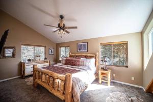 a bedroom with a wooden bed and a ceiling fan at Aspen Glow Lodge ~ Luxury Cabin in Duck Creek in Duck Creek Village