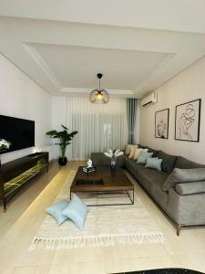 een woonkamer met een bank en een salontafel bij A Luxury 2BR with Big Pools Perfect for Family Summer Escape! in Monastir