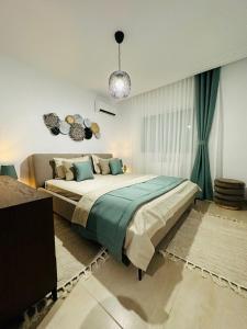 um quarto com uma cama grande e lençóis verdes em A Luxury 2BR with Big Pools Perfect for Family Summer Escape! em Monastir