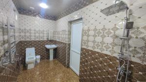 a bathroom with a toilet and a shower and a sink at Qafqaz Flower Villa in Gabala