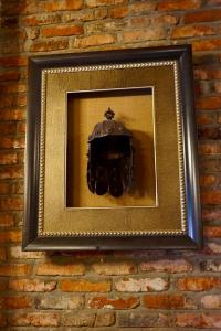 a picture of a helmet on a brick wall at Old Sighnaghi in Sighnaghi