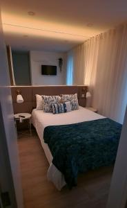 a bedroom with a large bed and a television at Ninho Citadino Aveiro in Aveiro