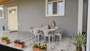 a white table and chairs on a patio with plants at Qafqaz Flower Villa in Gabala +15 photos