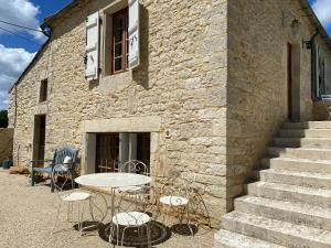 a table and chairs in front of a building at Picturesque renovated farmhouse with pool in Les Junies
