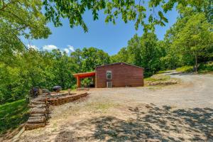 a cabin in the woods next to a dirt road at Fire Pit and Stunning Lake Views Shell Knob Home! in Shell Knob