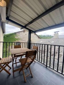 eine Terrasse mit einem Tisch und Stühlen auf dem Balkon in der Unterkunft L'Authentique - Terrasse - MyraConciergerie in Nay