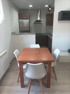 - une cuisine avec une table en bois et des chaises blanches dans l'établissement El Loft de Cris, à Béjar
