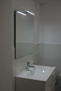 uma casa de banho branca com um lavatório e um espelho em Azul Cielo em Ayamonte