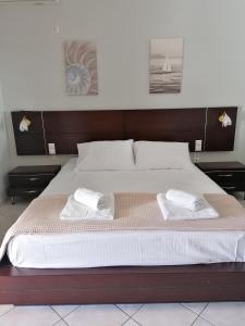 Lefakis Aegean Breeze Apartment في Órmos: غرفة نوم بسرير كبير عليها منشفتين