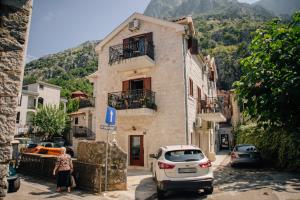 a building with a car parked in front of it at Filip Deluxe Rooms in Kotor
