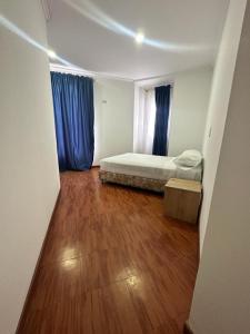 a small room with a bed and a wooden floor at Hotel Artistico in Bogotá