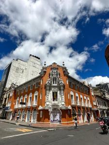 duży pomarańczowy budynek po stronie ulicy w obiekcie Hotel Artistico w mieście Bogota