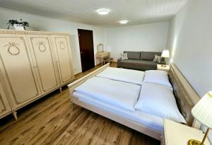 a bedroom with a large bed and a couch at UV Apartmány in Banská Štiavnica