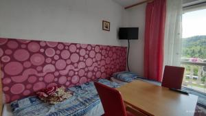 um quarto com uma cabeceira acolchoada cor-de-rosa e uma mesa em Tanie Noclegi Krysia Falsztyn em Falsztyn