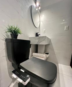 a bathroom with a black toilet and a mirror at Habitacion en Carrasco, cerca del aeropuerto in Montevideo