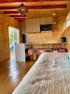 cocina con cama en una habitación en Cabaña de campo con vista al mar, en Ancud