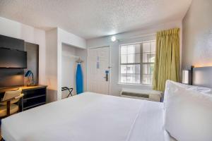 a bedroom with a large white bed and a window at Studio 6-San Antonio, TX - Six Flags in San Antonio