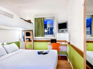 a bedroom with a bed and a desk with a chair at ibis budget Porto Alegre - Supereconômico in Porto Alegre