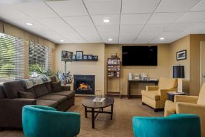 a waiting room with a couch and a fireplace at Quality Inn & Suites Chambersburg in Chambersburg