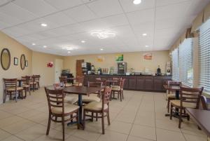 Quality Inn & Suites Chambersburg في تشامبرسبورغ: غرفة طعام مع طاولات وكراسي في مطعم