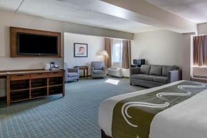 a hotel room with a bed and a flat screen tv at Quality Inn Lexington -Horse Park in Lexington