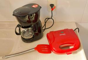 a blender sitting on a counter next to a red item at Studios Verdes hospedagens in São Pedro da Aldeia