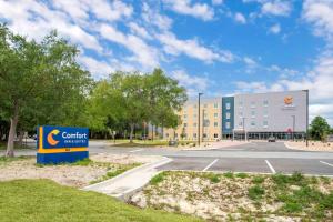 un edificio con un cartel delante de un aparcamiento en Comfort Inn & Suites Destin near Henderson Beach, en Destin