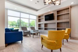 a living room with chairs and a couch and a tv at Comfort Inn & Suites Destin near Henderson Beach in Destin