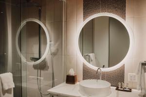 a bathroom with a sink and a mirror at CityFlatsHotel - Grand Rapids, Ascend Hotel Collection in Grand Rapids