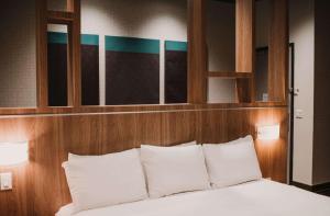 a bedroom with a bed with white pillows at CityFlatsHotel - Grand Rapids, Ascend Hotel Collection in Grand Rapids
