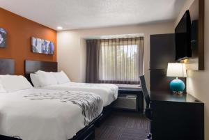 um quarto de hotel com duas camas e uma janela em Sleep Inn em Erie
