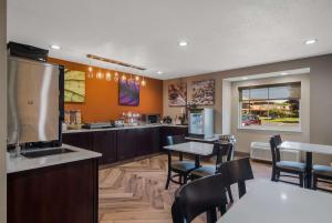 a restaurant with a kitchen with tables and chairs at Sleep Inn in Erie