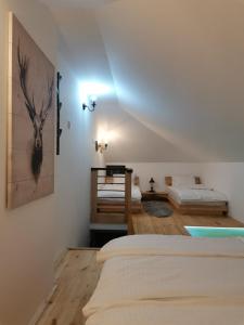 a bedroom with two beds and a painting on the wall at KATUN Apartmani & SPA in Divčibare