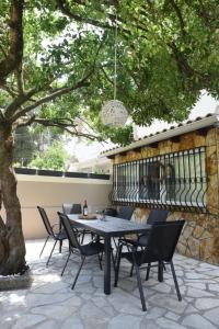 a patio with a table and chairs under a tree at Calma House in Kompítsion