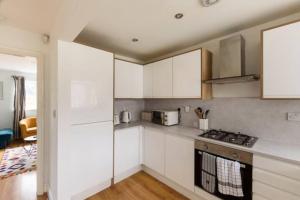a kitchen with white cabinets and a stove top oven at Overbury Lodge, Birmingham with FREE Parking in Northfield