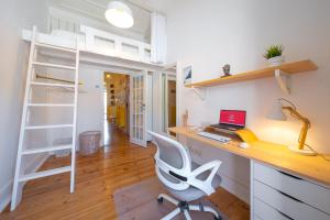 Zimmer mit einem Schreibtisch, einem Computer und einem Etagenbett in der Unterkunft Wanderful Home - Travel Themed Apartment in Lissabon