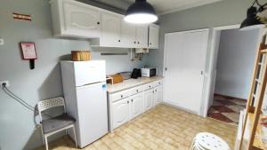 uma cozinha com armários brancos e um frigorífico branco em Li-miana Alojamento Local em Ponte de Lima