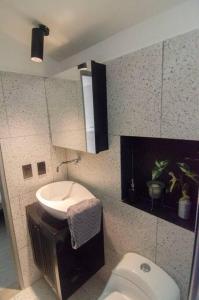 a small bathroom with a toilet and a sink at Design Studio Apartment with balcony and view in central and quiet area in Cali