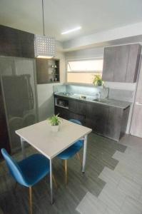 a kitchen with a white table and blue chairs at Design Studio Apartment with balcony and view in central and quiet area in Cali