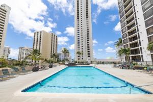ホノルルにあるGreat Ocean View Condo, Near Beach with Free Parking!の建物を背景にした大型スイミングプール