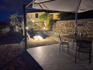 a patio with a table and a fire pit at night at Casa Mara - Diano Serreta in Diano Marina