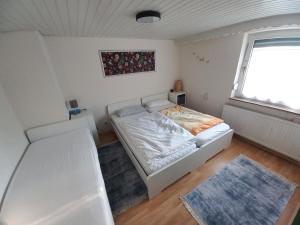 a bedroom with a white bed and a window at FeWo Heidenheim Bluewall in Heidenheim an der Brenz