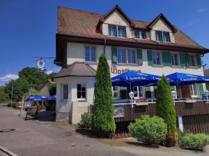 ein Gebäude mit blauen Sonnenschirmen davor in der Unterkunft Hotel "Cafe Verkehrt" - Wellcome Motorbiker, Berufsleute und Reisende im Schwarzwald in Oberhof