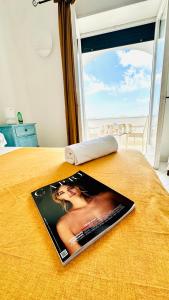 czasopismo siedzące na łóżku z oknem w obiekcie Villa La Zagara by CapriRooms w mieście Capri